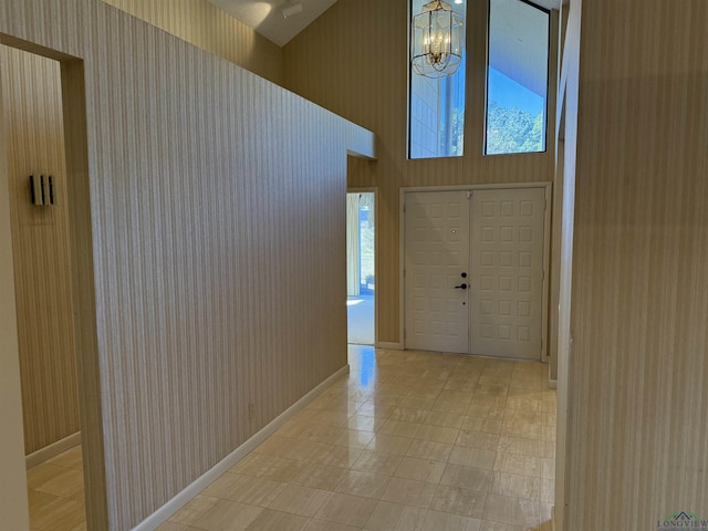 foyer featuring a notable chandelier and high vaulted ceiling