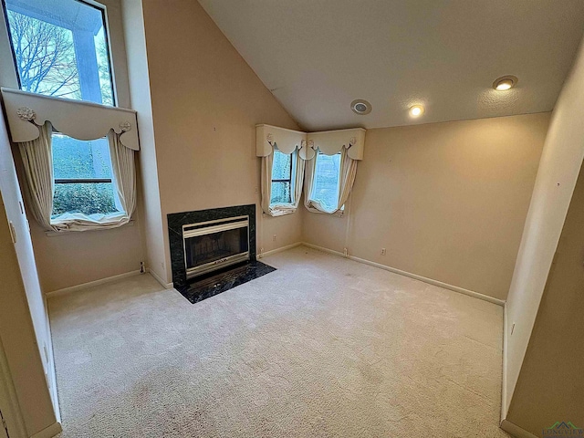 unfurnished bedroom with high vaulted ceiling, light colored carpet, and a premium fireplace