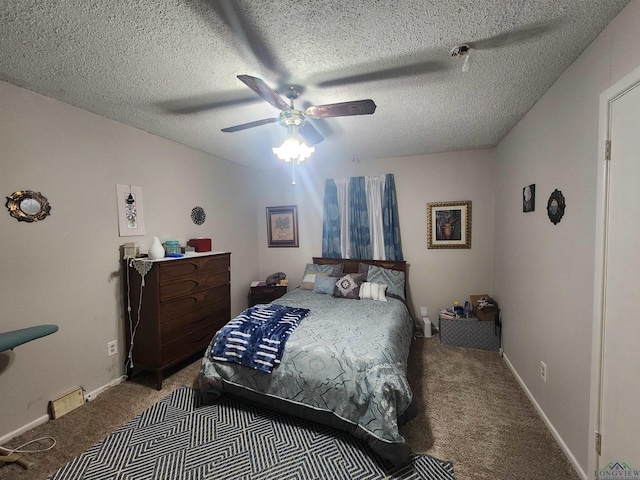 carpeted bedroom featuring ceiling fan and a textured ceiling