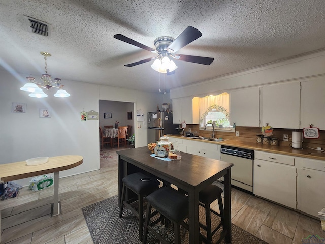 kitchen featuring stainless steel appliances, white cabinetry, sink, and a textured ceiling