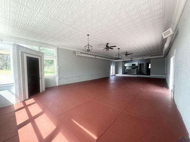 unfurnished living room with crown molding, tile patterned floors, ceiling fan, and visible vents