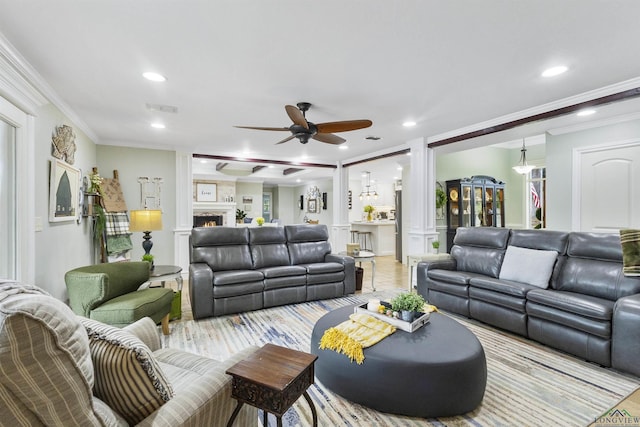 living area with ceiling fan, visible vents, a large fireplace, ornamental molding, and recessed lighting