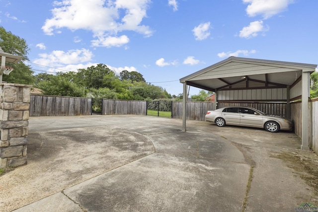 view of car parking featuring a carport, fence, and concrete driveway