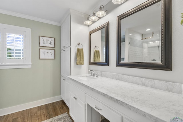 bathroom featuring vanity, ornamental molding, a shower, wood finished floors, and baseboards