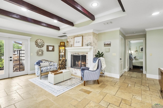 living room with a lit fireplace, ornamental molding, french doors, and stone tile flooring