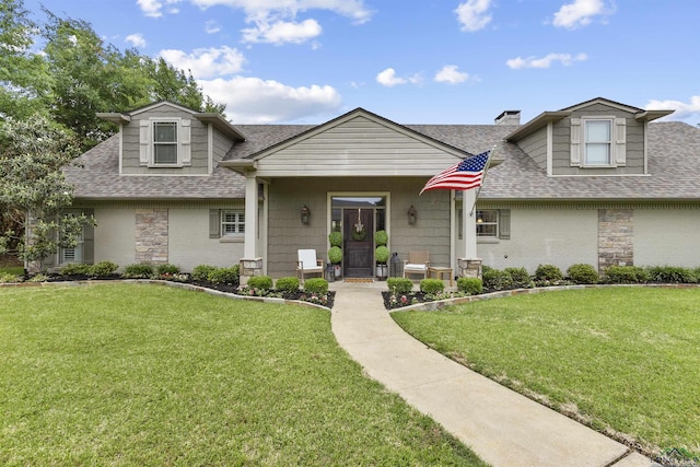 view of front of home featuring a chimney, roof with shingles, covered porch, and a front yard