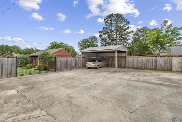 view of parking / parking lot with fence, a detached carport, and driveway