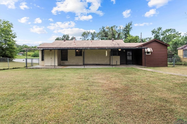 rear view of house with a lawn and a patio