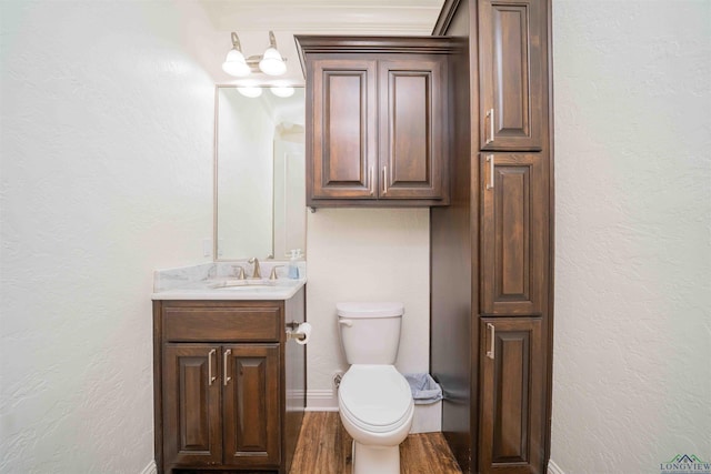 bathroom with vanity, toilet, baseboards, and wood finished floors