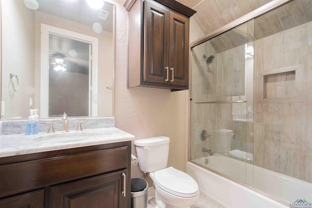 full bathroom featuring toilet, vanity, visible vents, a textured wall, and enclosed tub / shower combo
