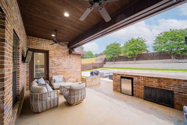 view of patio / terrace featuring area for grilling, an outdoor living space with a fire pit, a fenced backyard, and ceiling fan