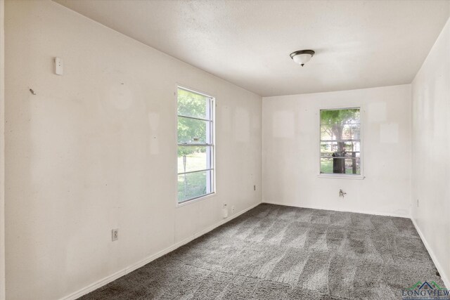 carpeted empty room featuring baseboards