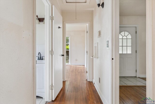 hallway with attic access and hardwood / wood-style flooring