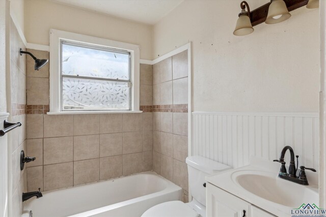 bathroom featuring a wainscoted wall, shower / bathing tub combination, vanity, and toilet