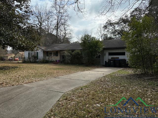 single story home with a garage and a front lawn