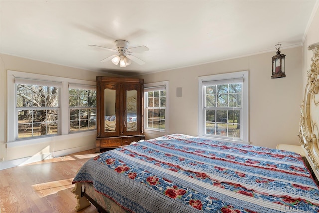 bedroom with ceiling fan, hardwood / wood-style floors, and ornamental molding