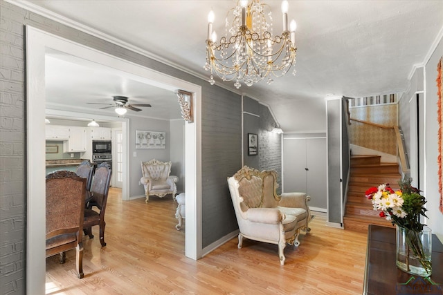 sitting room featuring lofted ceiling, crown molding, ceiling fan with notable chandelier, and light wood-type flooring