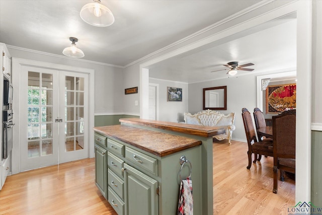 kitchen featuring ceiling fan, french doors, crown molding, light hardwood / wood-style floors, and green cabinetry