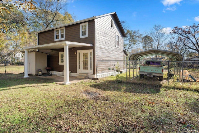 rear view of house with a carport and a lawn