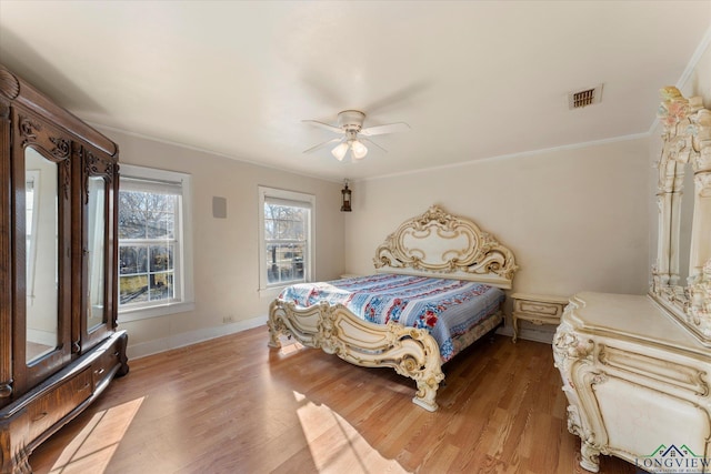 bedroom featuring hardwood / wood-style flooring, ceiling fan, and crown molding