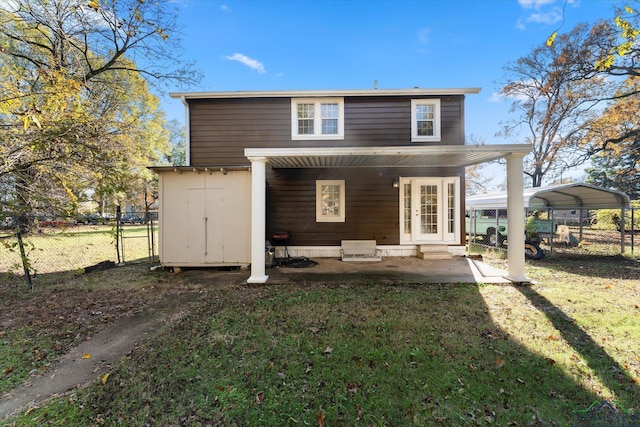 back of property with a yard and a carport