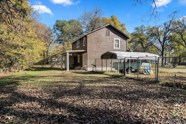 rear view of property featuring a carport and a lawn