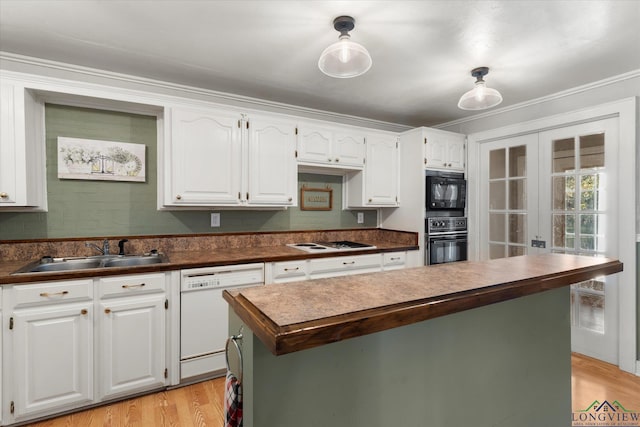 kitchen with white cabinetry, sink, a kitchen island, and black appliances