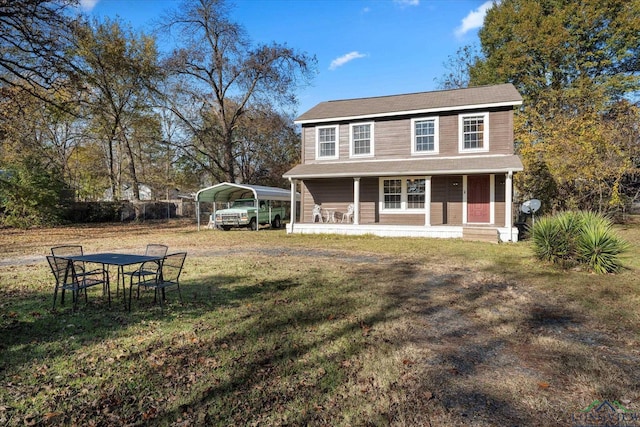 view of front of house with covered porch, a front yard, and a carport