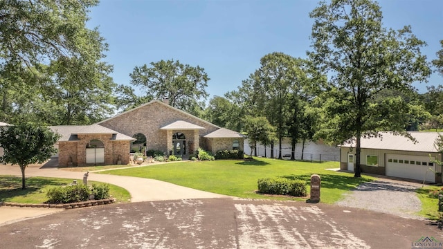 107 Kelly Ct, Marshall, TX 75672 - view of front of home with curved driveway, a front lawn, brick siding, and an attached garage