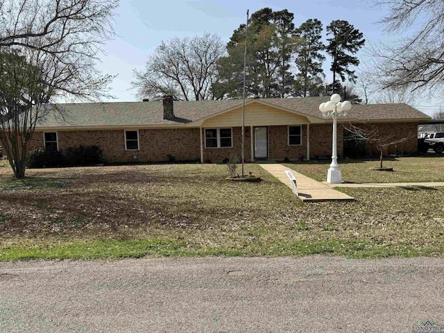 single story home with brick siding and a chimney
