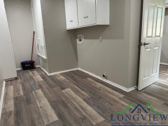 clothes washing area featuring dark hardwood / wood-style flooring, hookup for a washing machine, and cabinets