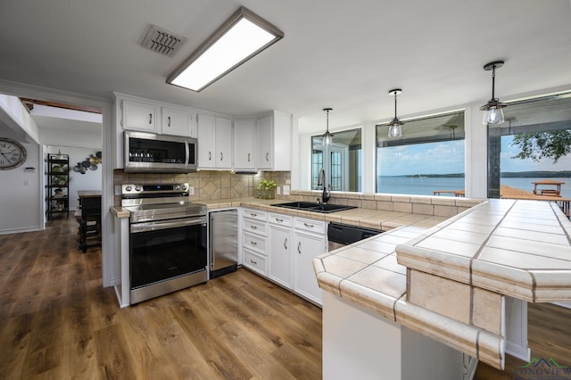 22551 Pine St, Frankston, TX 75763 - kitchen with stainless steel appliances, tile countertops, plenty of natural light, and a peninsula