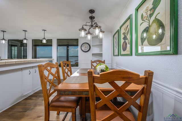 22551 Pine St, Frankston, TX 75763 - dining room featuring dark wood-type flooring, a decorative wall, wainscoting, and a chandelier