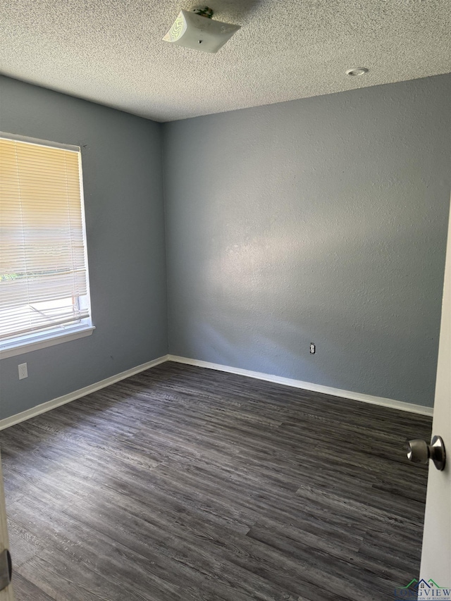 unfurnished room with a textured ceiling and dark hardwood / wood-style flooring