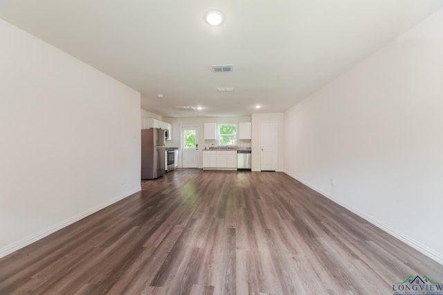 801 W Walnut St, Longview, TX 75601 - unfurnished living room with dark wood finished floors, baseboards, and recessed lighting