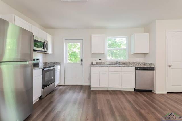 801 W Walnut St, Longview, TX 75601 - kitchen featuring appliances with stainless steel finishes, dark wood-style flooring, and light stone countertops
