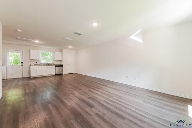 801 W Walnut St, Longview, TX 75601 - unfurnished living room with dark wood-style floors, recessed lighting, baseboards, and a sink