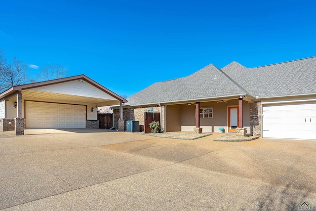 ranch-style house featuring a garage and central AC