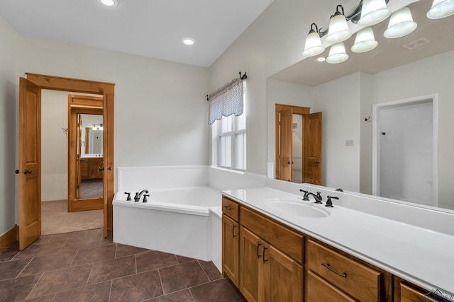 bathroom featuring vanity, a washtub, and tile patterned floors