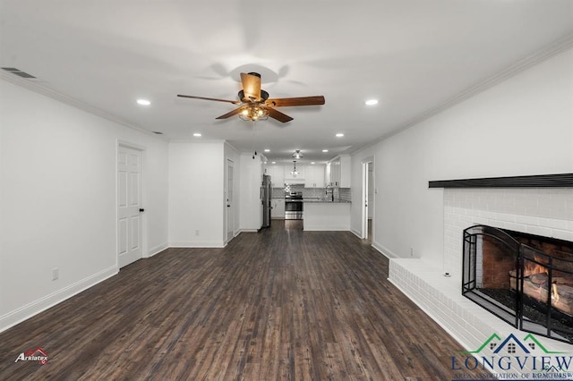 unfurnished living room with dark wood-type flooring, ceiling fan, a brick fireplace, and ornamental molding