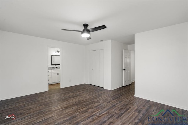 unfurnished bedroom featuring ceiling fan, dark hardwood / wood-style floors, ensuite bath, a closet, and sink