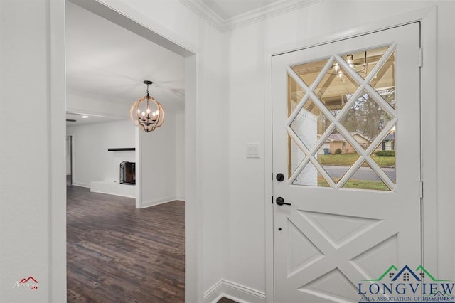 entryway featuring a wood stove, dark hardwood / wood-style floors, ornamental molding, and a chandelier