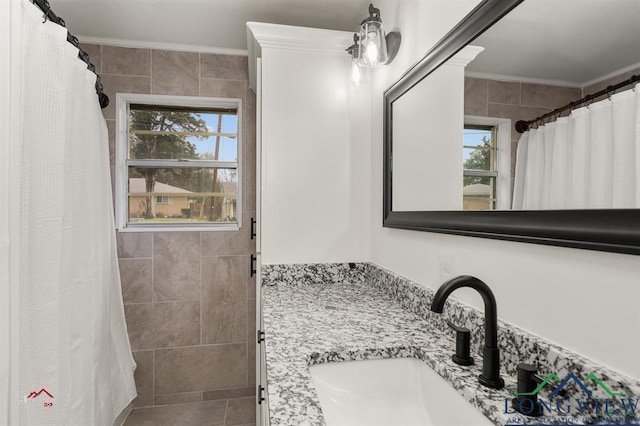 bathroom with ornamental molding, a healthy amount of sunlight, and vanity