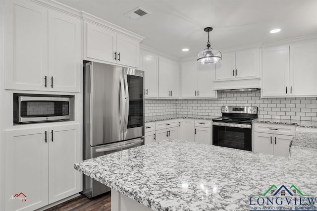 kitchen with appliances with stainless steel finishes, dark hardwood / wood-style floors, backsplash, pendant lighting, and white cabinets