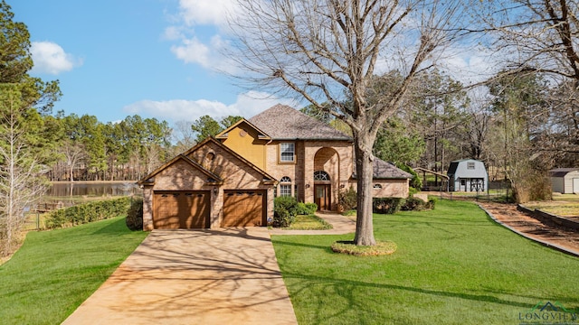 view of front facade featuring brick siding, a garage, driveway, and a front lawn