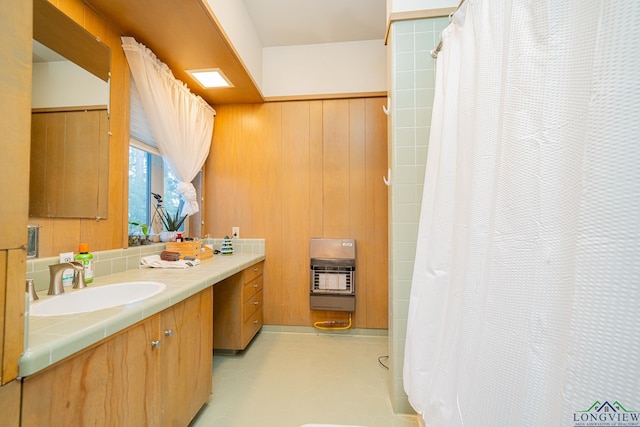 bathroom featuring heating unit, wooden walls, vanity, and concrete floors