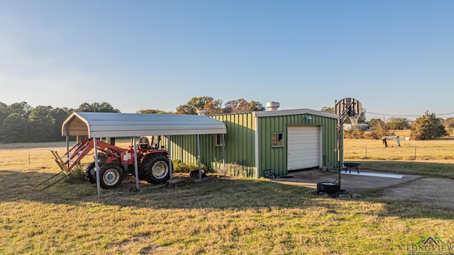 view of outbuilding featuring a carport, a garage, and a lawn