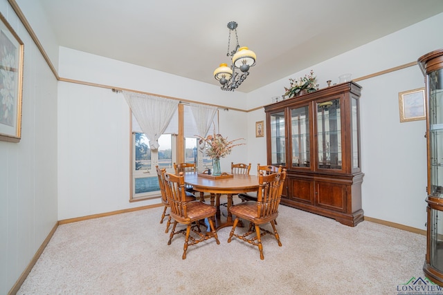 carpeted dining area with an inviting chandelier