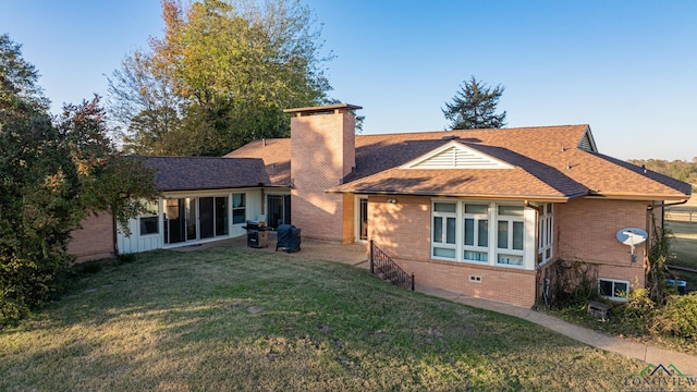 rear view of property with a lawn