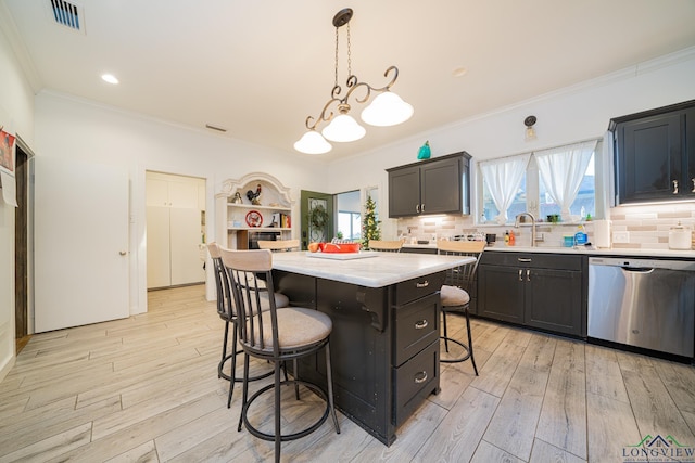 kitchen with a center island, sink, a kitchen breakfast bar, stainless steel dishwasher, and pendant lighting